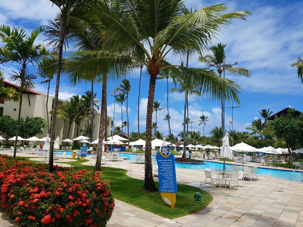 ein Resort mit einem Surfbrett in der Mitte eines Pools in der Unterkunft Flat Marulhos Resort in Porto De Galinhas