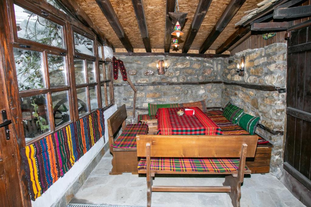 a room with a bed and a table with colorful blankets at The Tinkov house in Lovech in Lovech