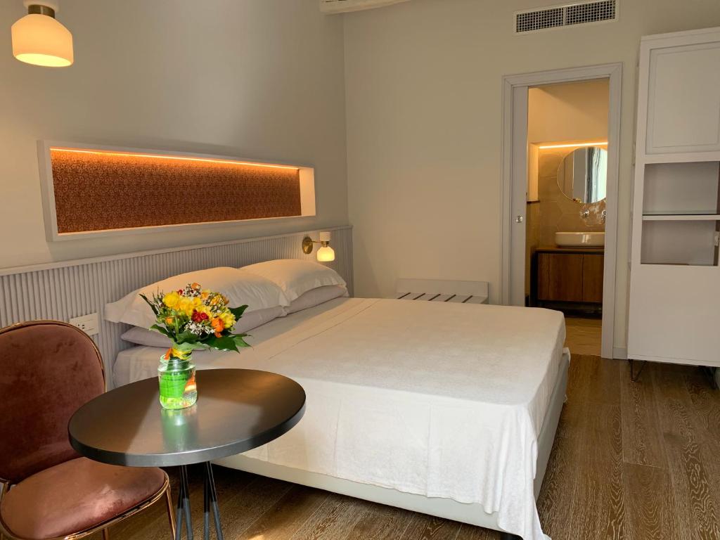 ein Hotelzimmer mit einem Bett und einem Tisch mit Blumen darauf in der Unterkunft B&B Raponsoli in Tropea