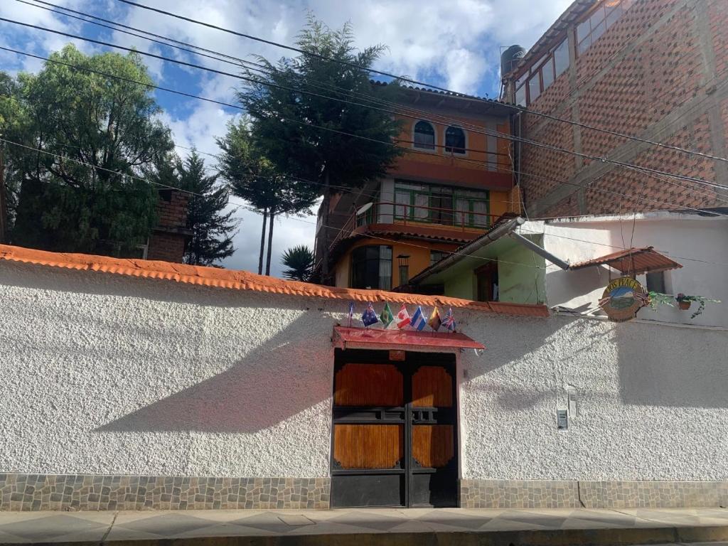un bâtiment blanc avec une porte avec des oiseaux. dans l'établissement Jo´s Place, à Huaraz