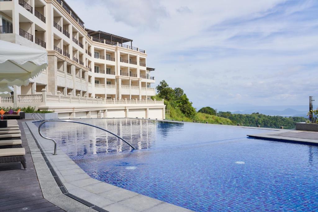 un hotel con piscina di fronte a un edificio di Twin Lakes Hotel a Tagaytay