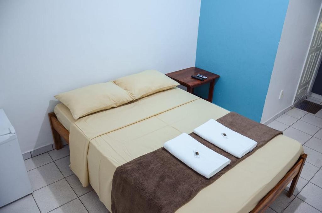 Una cama en una habitación con dos toallas blancas. en HOTEL XENIOS, en Macapá