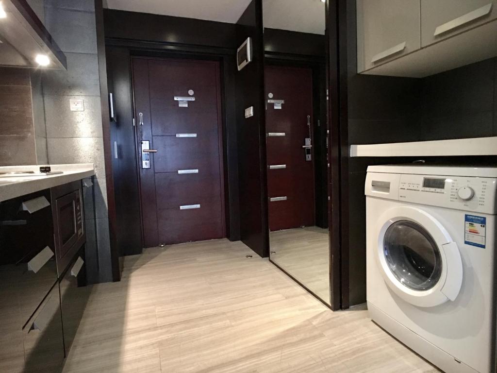 uma lavandaria com máquina de lavar e secar roupa em Nanjing Kaibin Apartment - Kai Run Jin Cheng em Nanquim