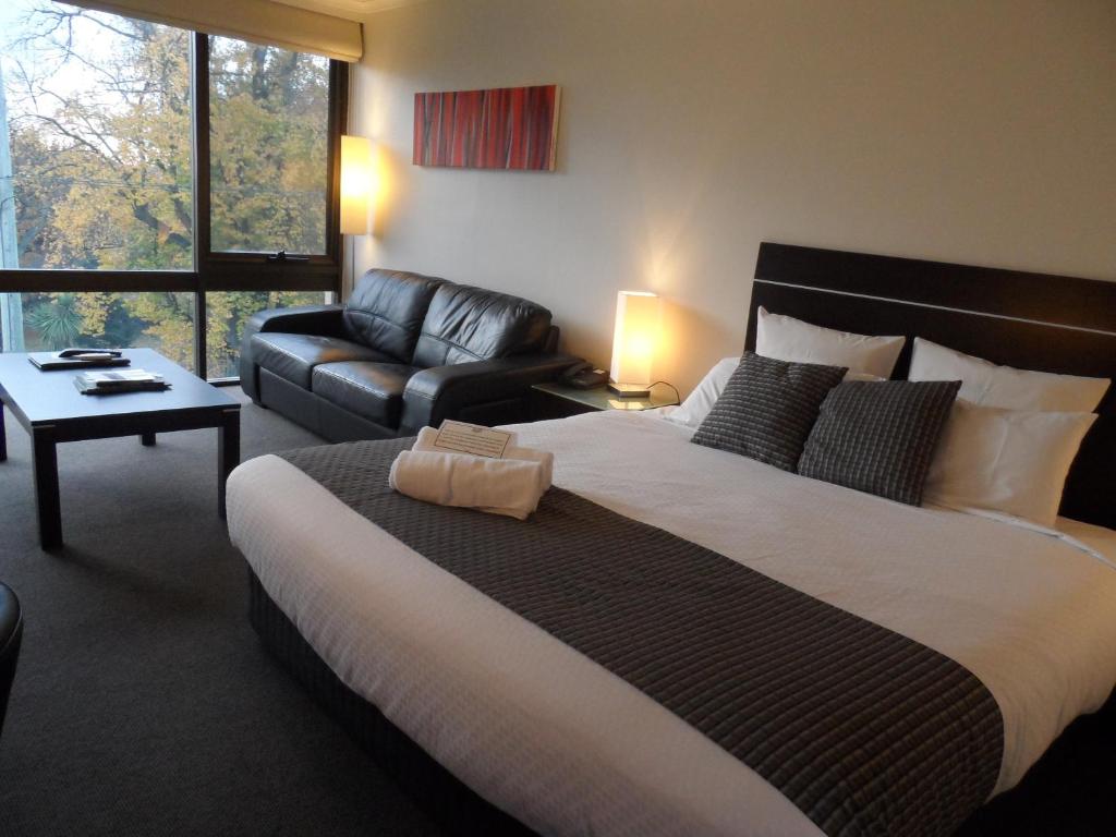 a bedroom with a large bed and a couch at Commodore Regent in Launceston