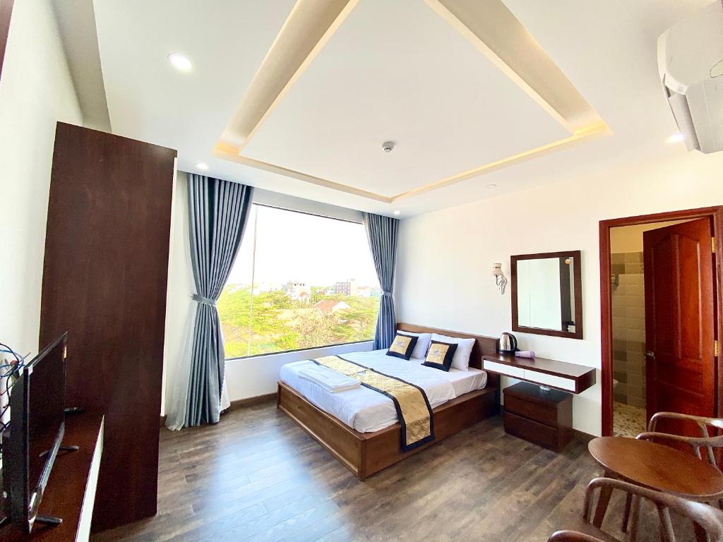 a bedroom with a bed and a large window at HOTEL ĐỨC THÀNH 2 in Con Dao
