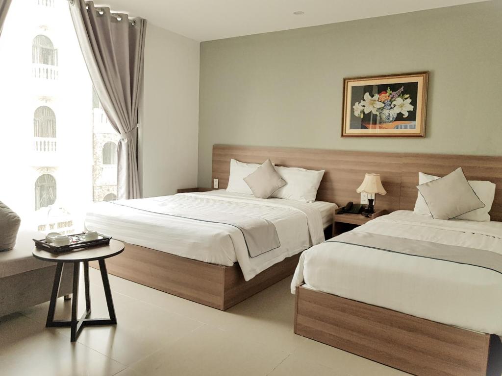 Postel nebo postele na pokoji v ubytování An Hoi Canary Hotel