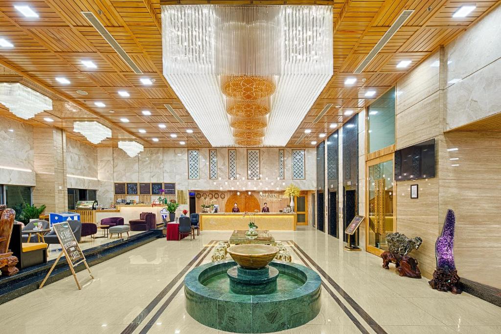 a lobby with a fountain in the middle of a building at Nhu Minh Plaza Danang Hotel in Danang