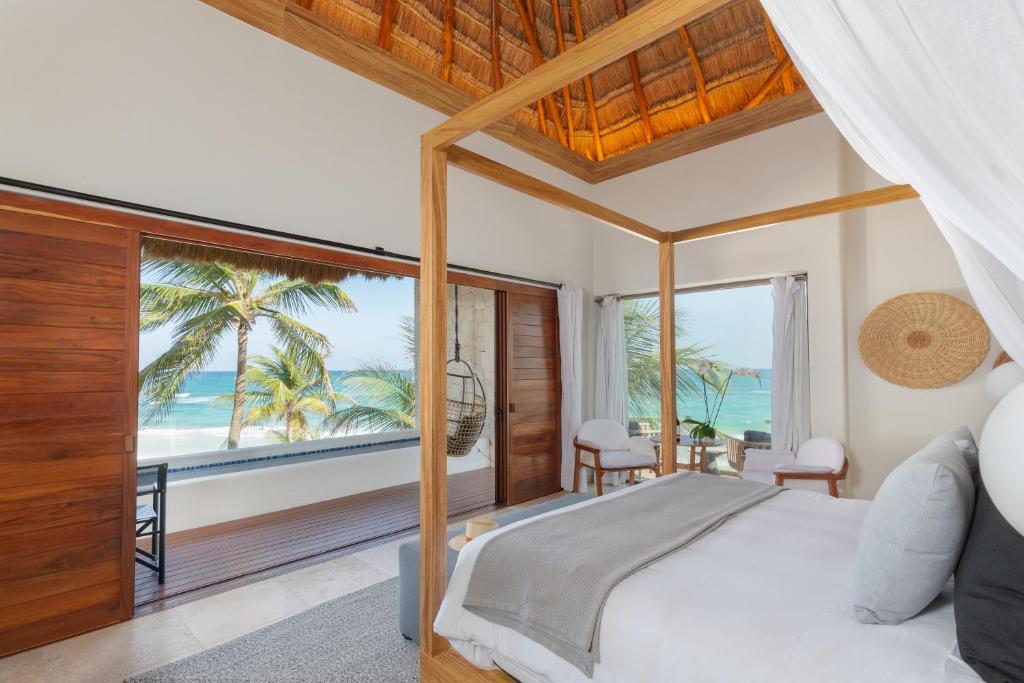 a bedroom with a bed with a view of the ocean at Tago Tulum by G Hotels in Tulum