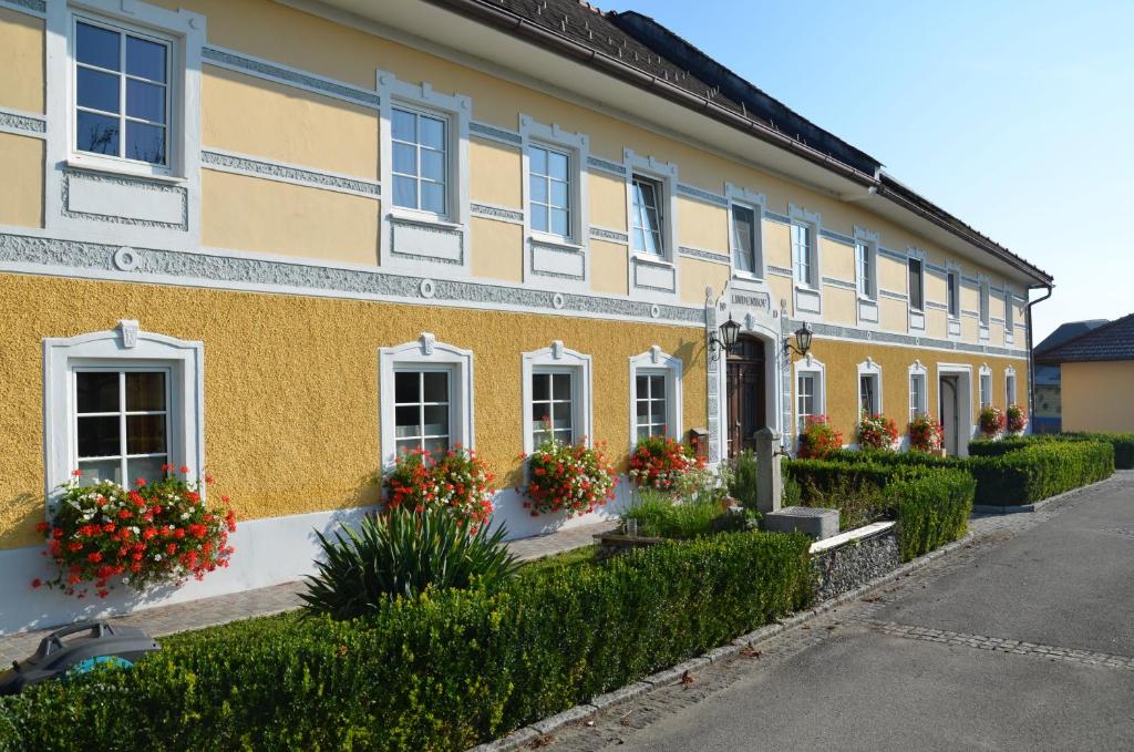 a yellow building with flowers in the windows at Lindenhof- Fam. Forstmayr in Haag