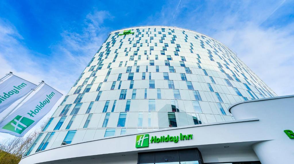 a tall building with a sign in front of it at Holiday Inn Hamburg - City Nord by IHG in Hamburg