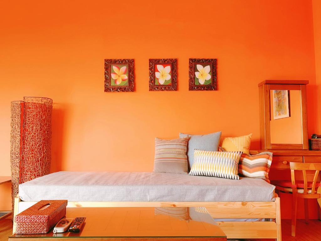 a bedroom with an orange wall with a bed at Ibali Hostel in Magong