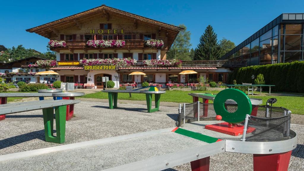um grupo de mesas de piquenique em frente a um edifício em Bruggerhof - Camping, Restaurant, Hotel em Kitzbühel