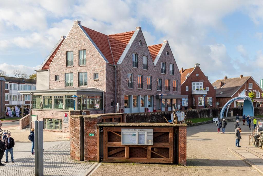 ein Gebäude mit einem Schild in der Mitte einer Straße in der Unterkunft Mingers Hotel in Neuharlingersiel