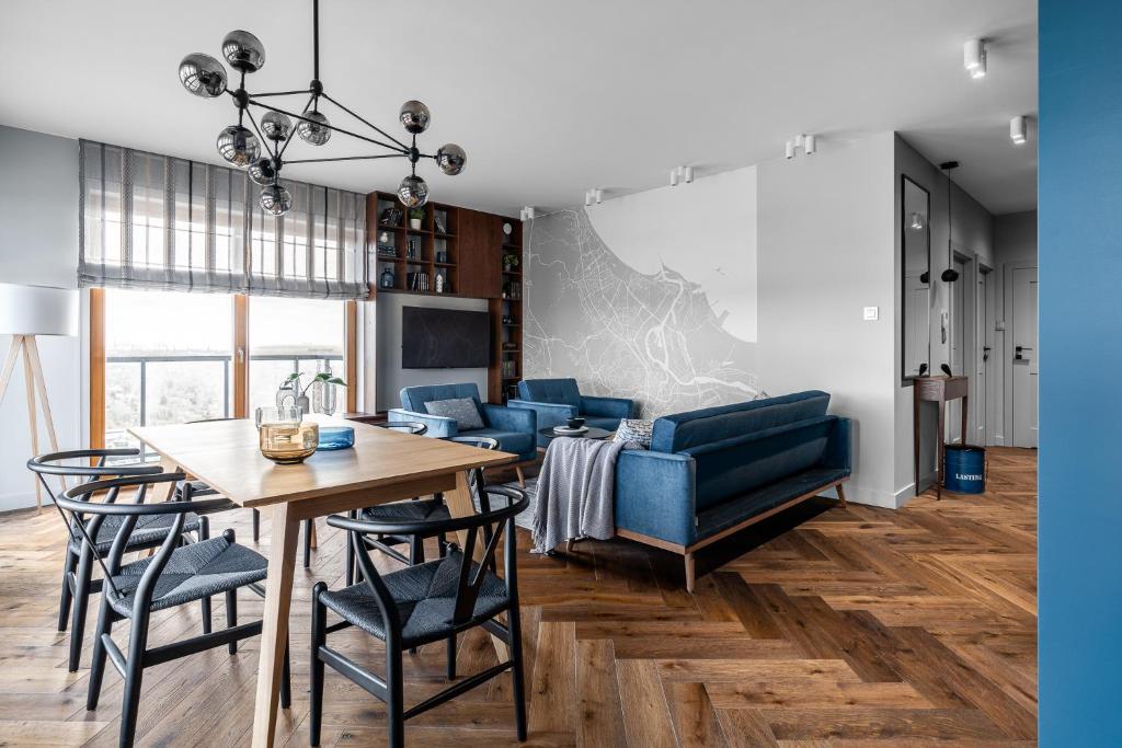 a living room with a table and a blue couch at Sea view apartment in Gdańsk
