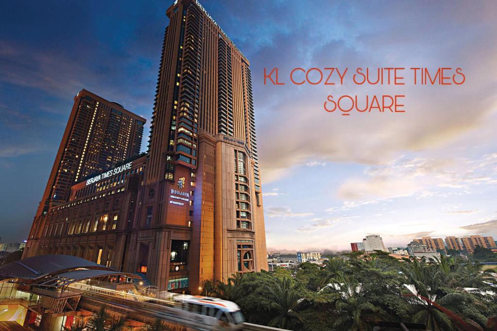een hoog gebouw met een trein ervoor bij KL Cozy Suite Times Square in Kuala Lumpur