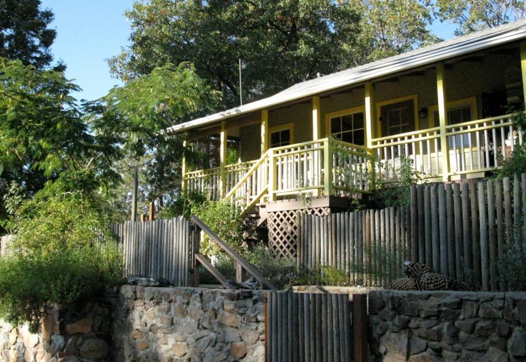 uma casa amarela com uma cerca em frente em Fivespot Cabin em Pinehurst