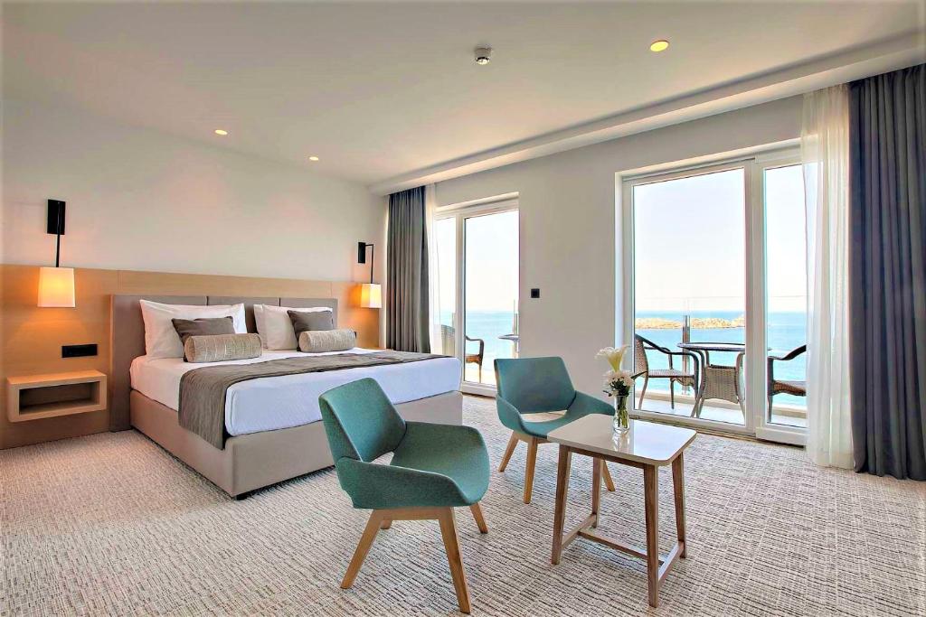 a bedroom with a bed and a room with a balcony at Royal Neptun Hotel in Dubrovnik