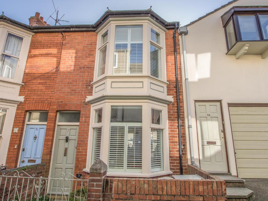 a brick house with a large window on it at Seahorse Cottage in Weymouth