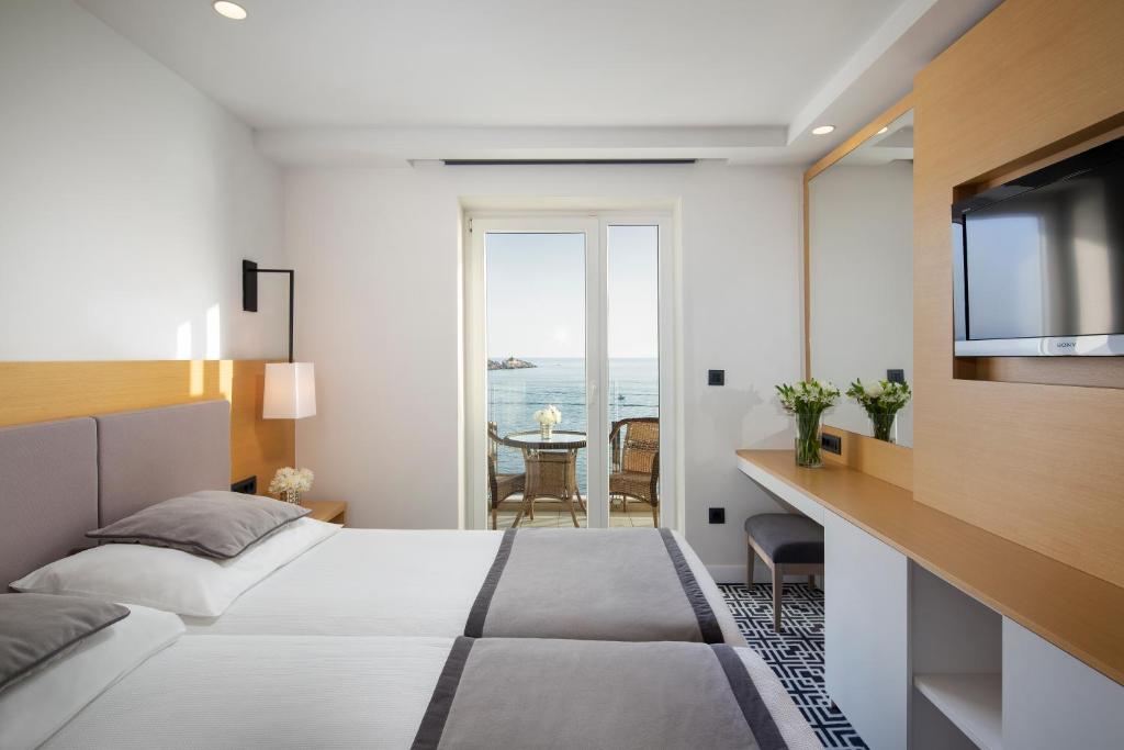 a hotel room with a bed and a television at Royal Neptun Hotel in Dubrovnik