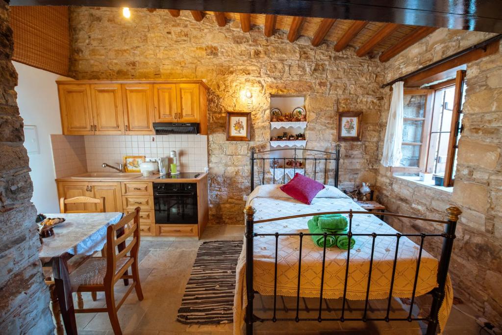 a bedroom with a bed and a table in a room at Constantias stone houses in Lofou