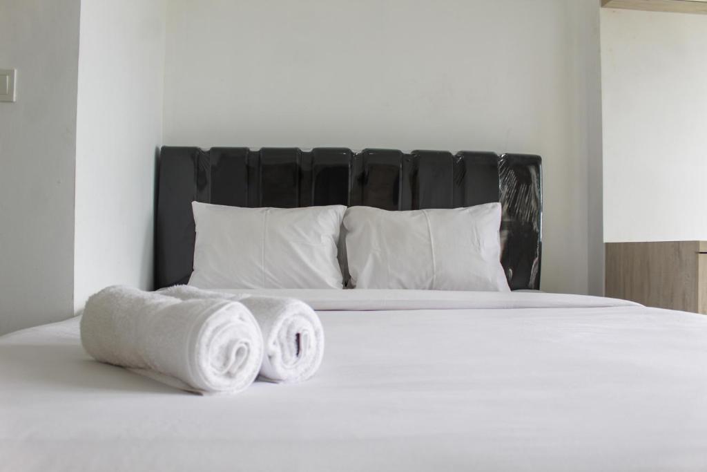 a bed with three rolled up towels on it at Minimalist Studio Apartment at Poris 88 with City View By Travelio in Tangerang