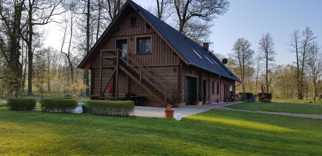 una gran casa de madera con techo de gambrel en Ferienwohnung Wasserlilie en Kolonie