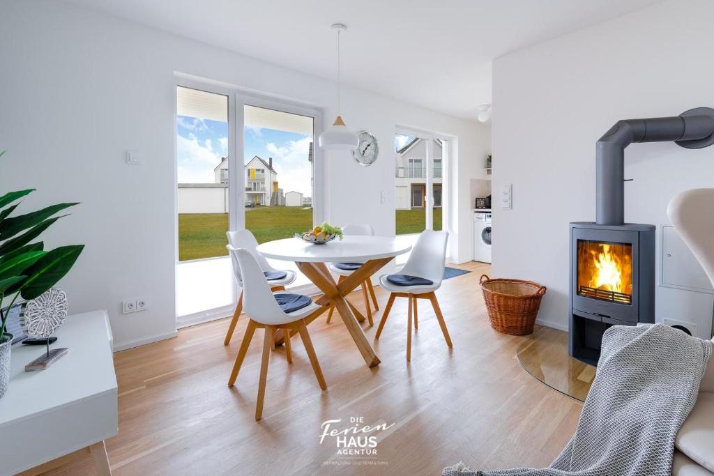 a living room with a table and a fireplace at Godewind in Olpenitz