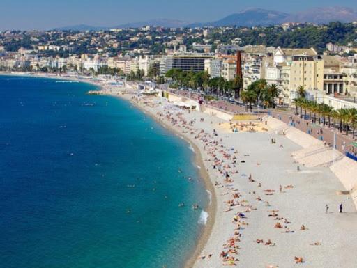 a beach with a lot of people and the ocean at My rima in Antibes