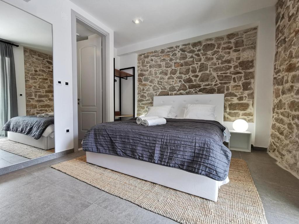 a bedroom with a bed and a stone wall at FJAKA Boutique Apartments in Split