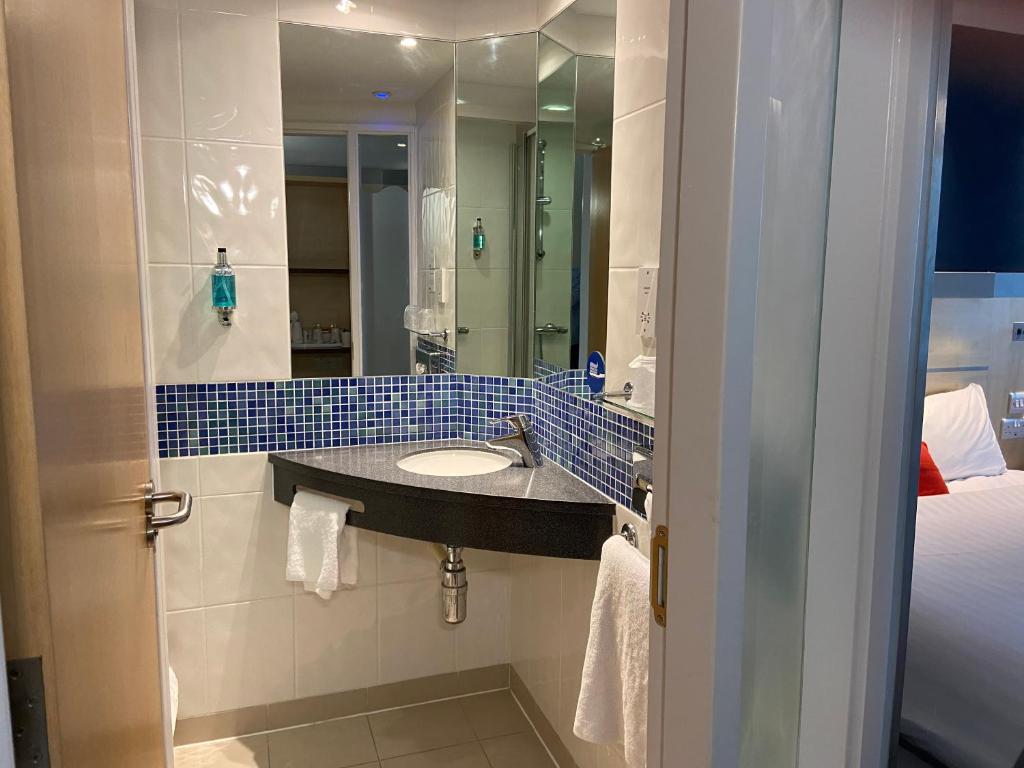 a bathroom with a sink and a mirror at Holiday Inn Express Ramsgate – Minster by IHG in Minster