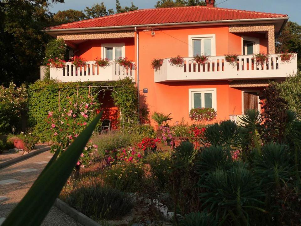 uma casa laranja com flores à frente em Apartments ADELA em Polje