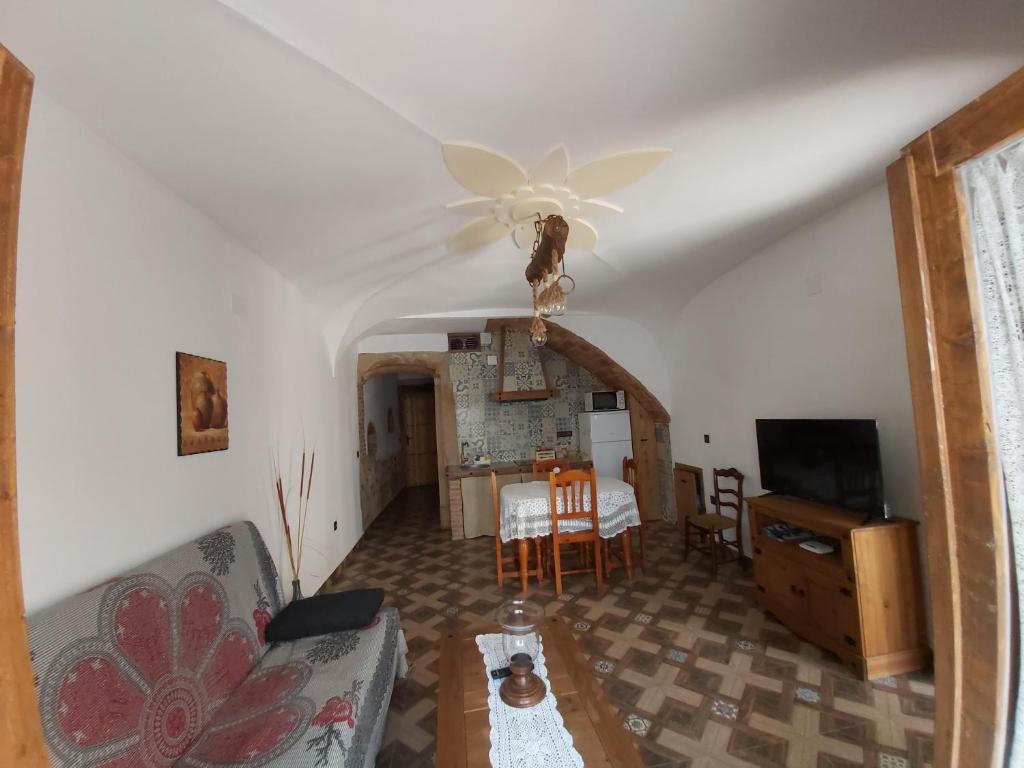 a living room with a couch and a ceiling fan at La casina de Carmina in Arroyomolinos de Montánchez