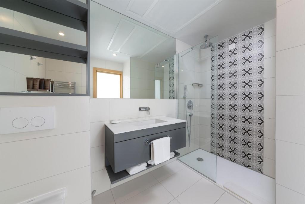 a white bathroom with a sink and a mirror at Royal Neptun Hotel in Dubrovnik