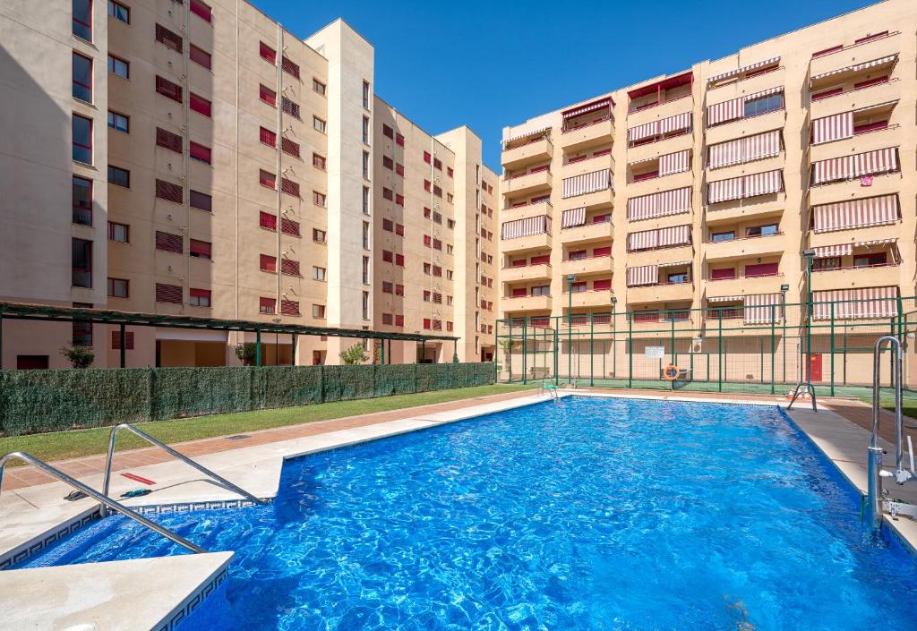 une piscine en face de deux bâtiments dans l'établissement WintowinRentals Parque Litoral, Family & Málaga, à Malaga