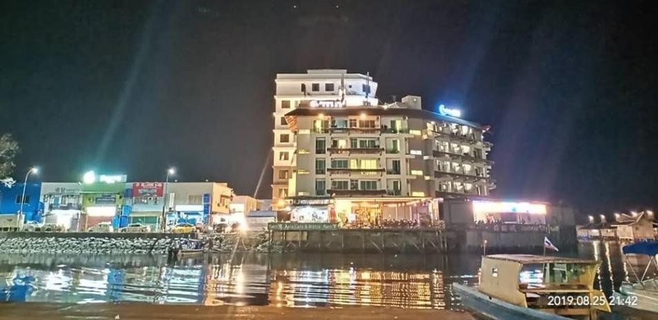 a large building at night next to a body of water at Sipadan Inn 3 in Semporna