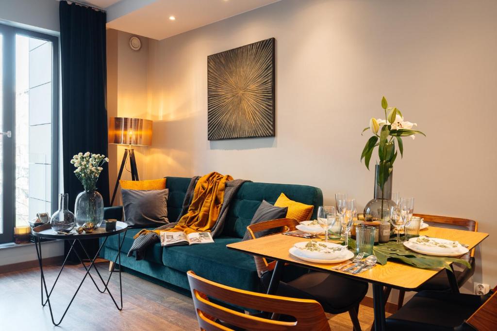 ein Wohnzimmer mit einem grünen Sofa und einem Tisch in der Unterkunft Veronese Apartments by LoftAffair in Krakau