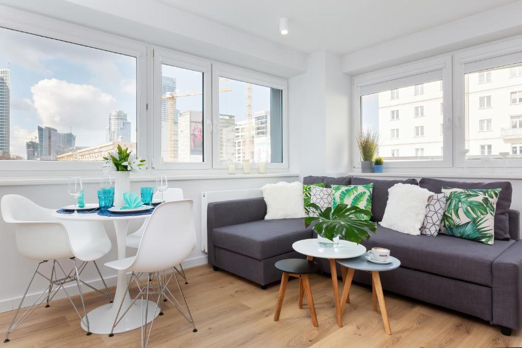 a living room with a couch and a table at Deluxe Studio Warsaw City Center by Renters in Warsaw