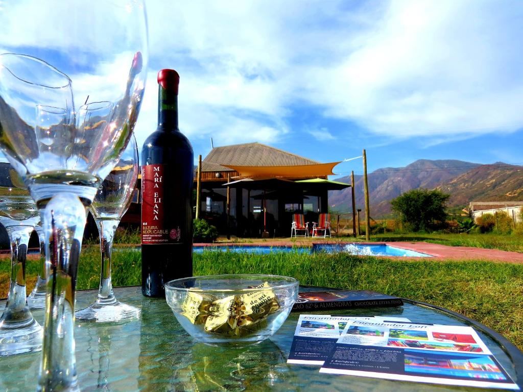 una mesa con copas de vino y una botella de vino en Encantador Loft, entre Viñas, Valles y Piscina Privada, en Santa Cruz