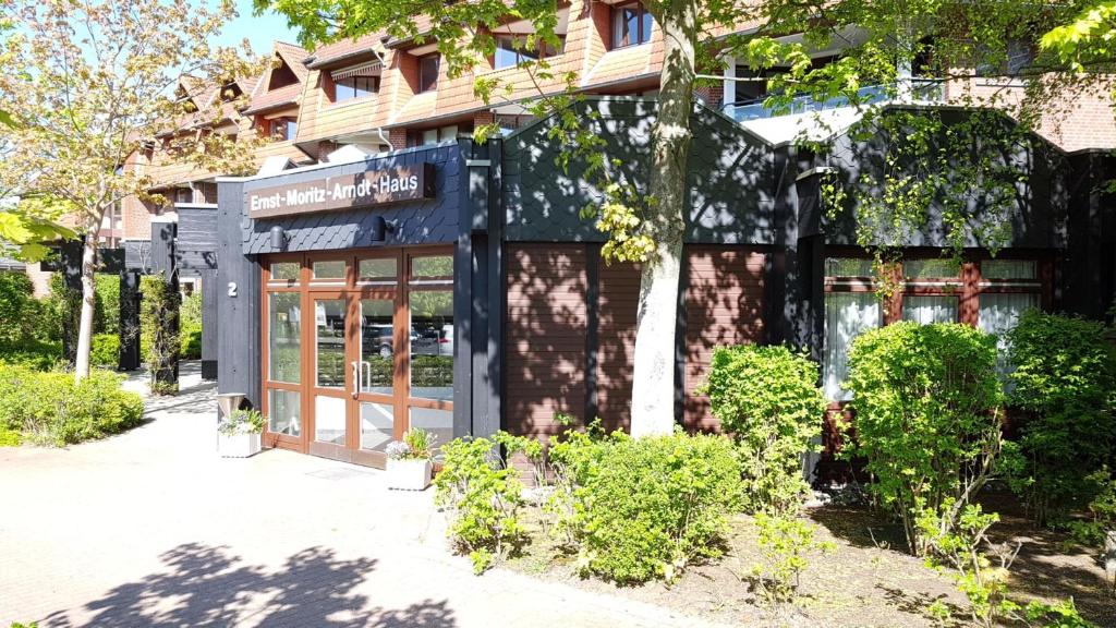 a store front of a building with trees and bushes at PEMATRA Ferienwohnungen Ostseestrasse 2 in Travemünde