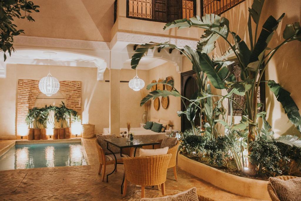 a room with a table and chairs and a swimming pool at Riad l'Oiseau du Paradis in Marrakech