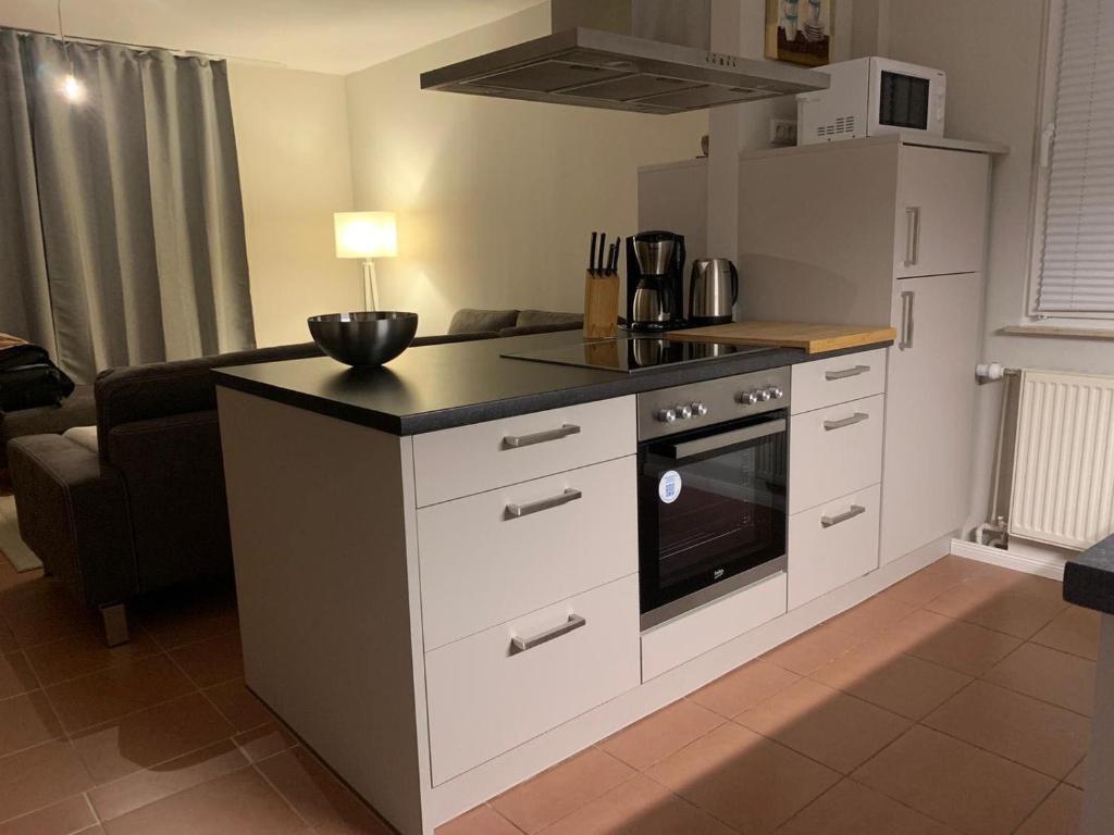 a kitchen with a stove top oven next to a couch at Ferienwohnung-Strandspaziergang, grosse Wohnung in Börgerende-Rethwisch