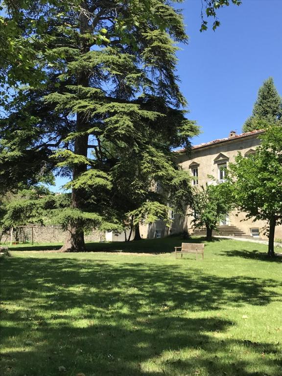 un parc avec un banc devant un bâtiment dans l'établissement Les cèdres, à Chalabre