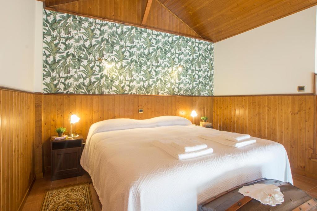 a bedroom with a large white bed with a floral wallpaper at Mortazel River Houses in Montazel