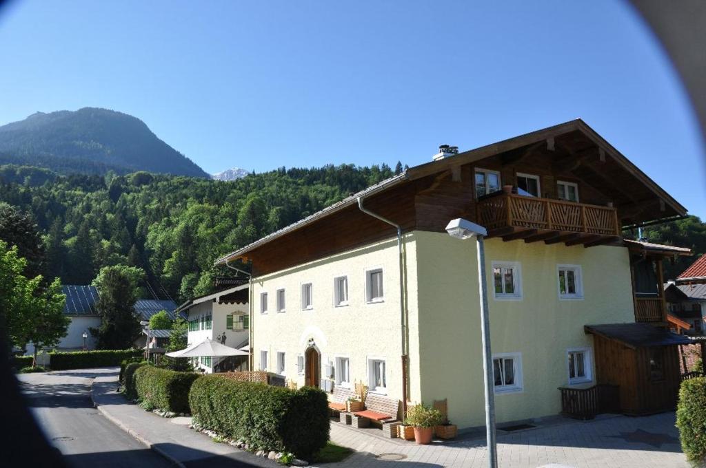 una grande casa bianca con tetto in legno di Ferienwohnung Haus Datz in Berchtesgaden a Berchtesgaden