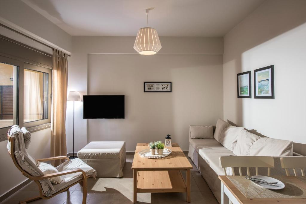 ein Wohnzimmer mit einem Sofa und einem Tisch in der Unterkunft Caravel Apartments Stalis in Stalida