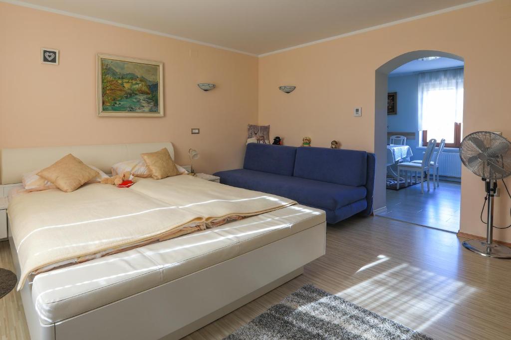 1 dormitorio con 1 cama y 1 sofá azul en Apartments Pr Fajfarju, en Bled