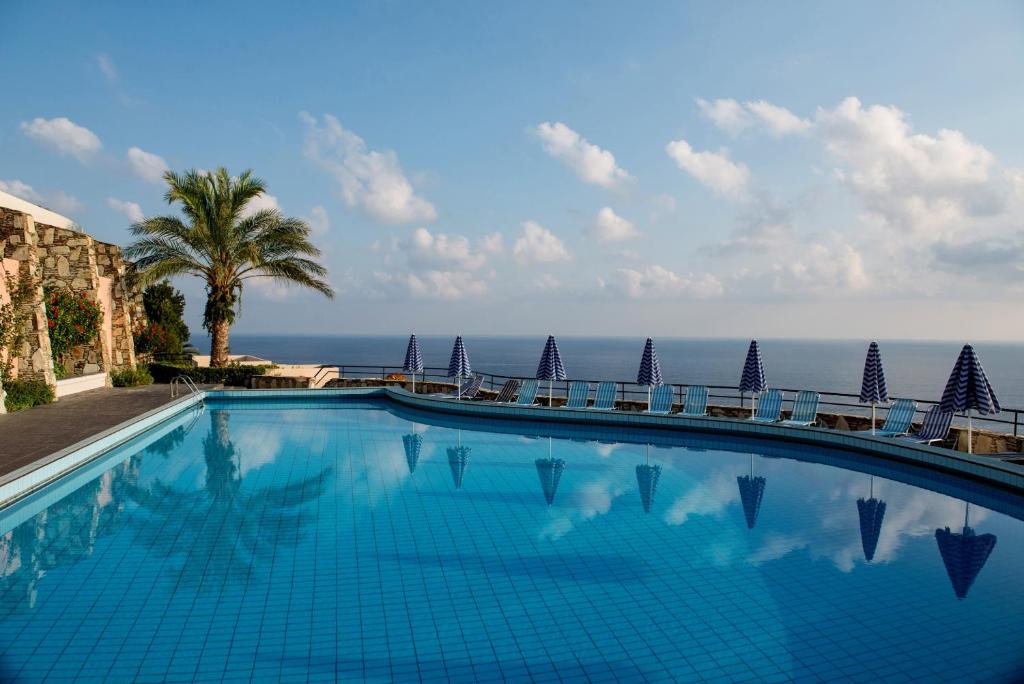 a large swimming pool with a blue sky at Athina Palace Resort & Spa in Agia Pelagia