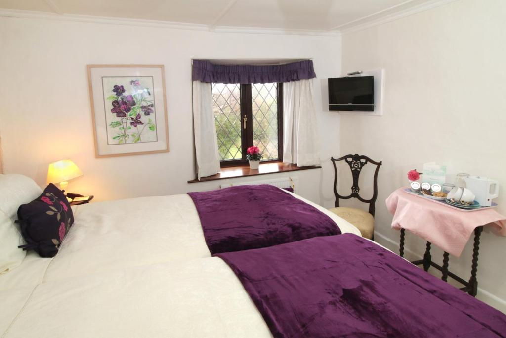 a bedroom with a bed with a purple blanket at Mellowvean in St. Agnes