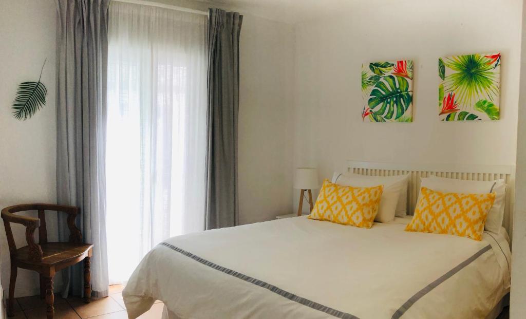 a bedroom with a bed with yellow pillows and a window at Casa-Casita in Marbella