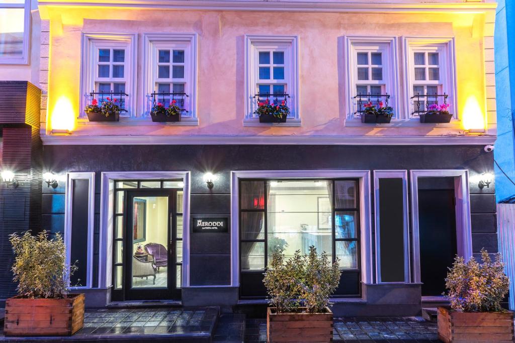 a pink house with potted plants in front of it at Meroddi La Porta Hotel in Istanbul